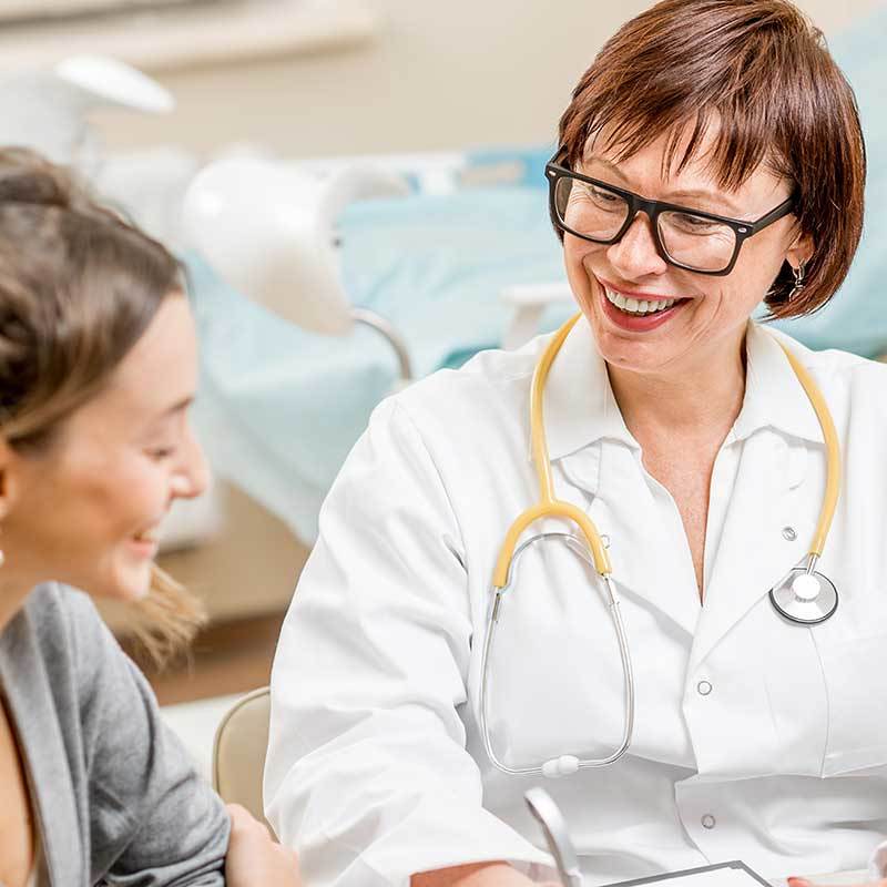 Eine lächelnde Ärztin mit einer Patientin