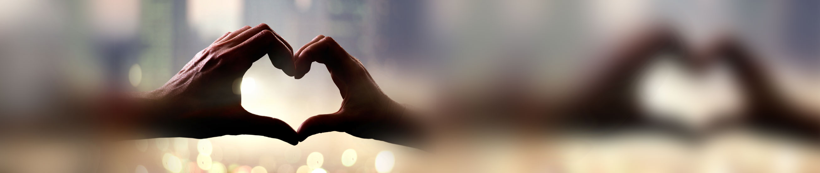 Das zeigt Hände, die ein Herz formen