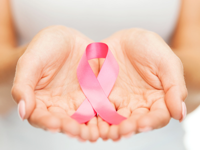 healthcare and medicine concept - womans hands holding pink breast cancer awareness ribbon
