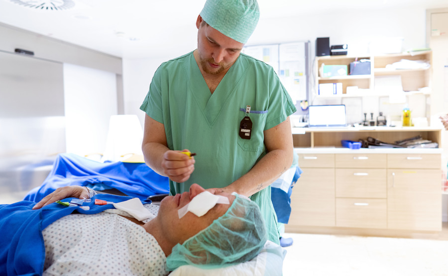 Pfleger tropft Patienten ein