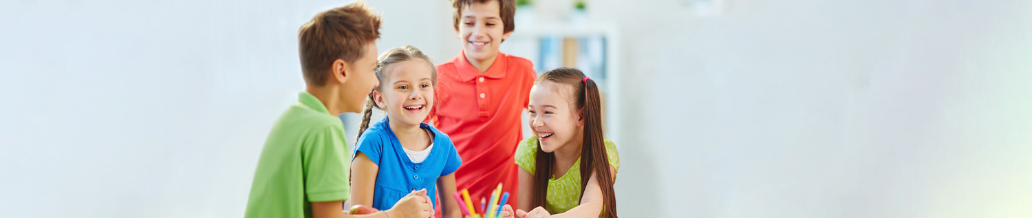 Das Foto zeigt zwei Buben und zwei Mädchen, die sehr glücklich sind und gemeinsam lachen