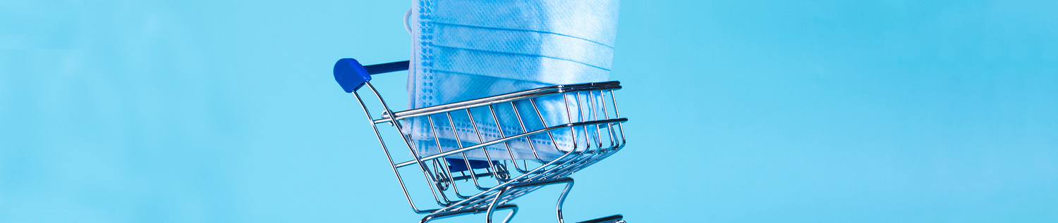 Das Bild zeigt einen Einkaufswagen mit einer medizinischen Maske.