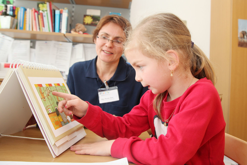 Das Bild zeigt eine Therapeutin mit Patientenkind.