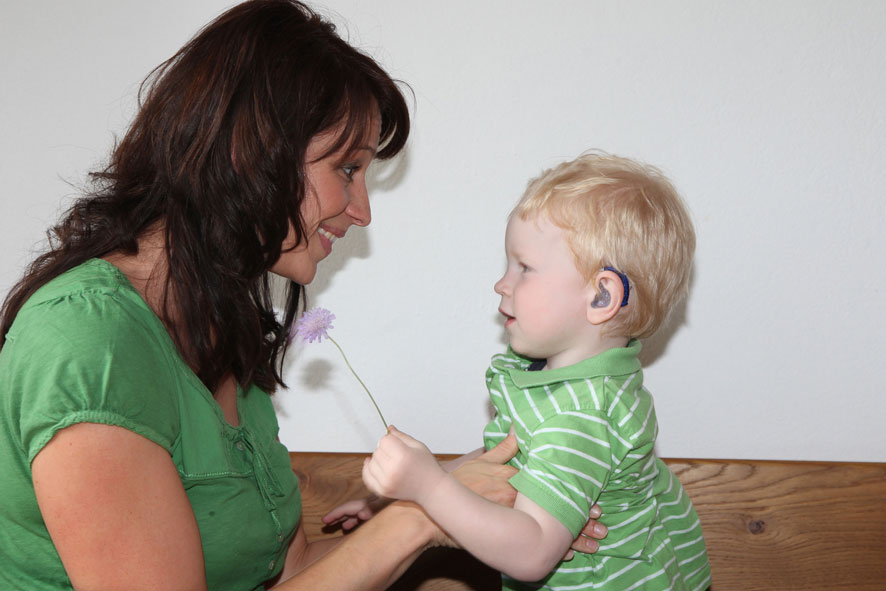 Logopädin bei der Arbeit mit einem Kind.