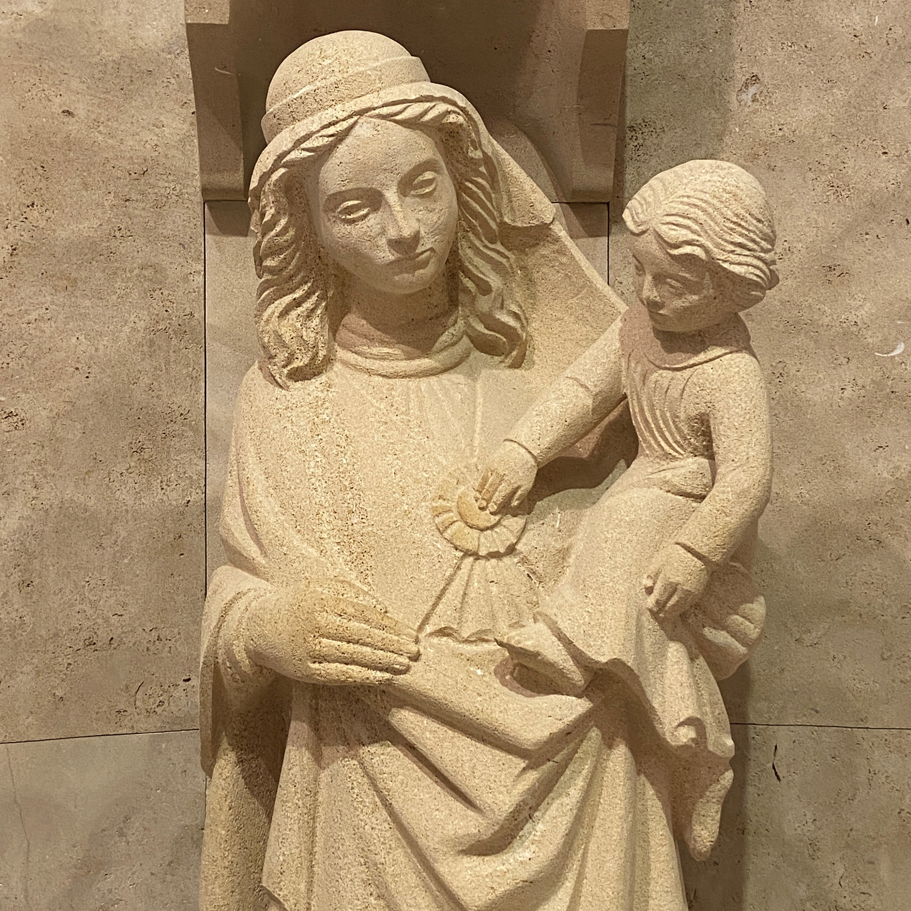 Abgebildet ist die Marienstatue mit Jesuskind am Arm, die in der Krankenhauskirche steht. 