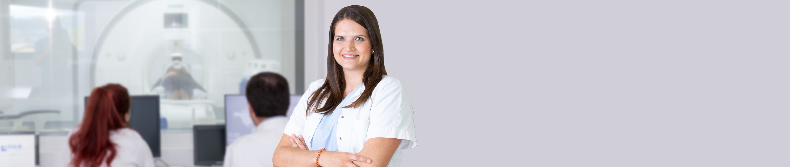 Mitarbeiterin im Vordergrund, MRT im Hintergrund