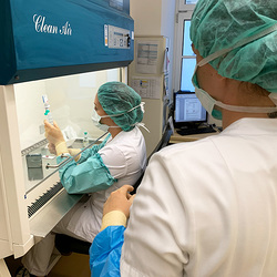 Zu sehen ist eine Mitarbeiterin, die steril arbeitet. 