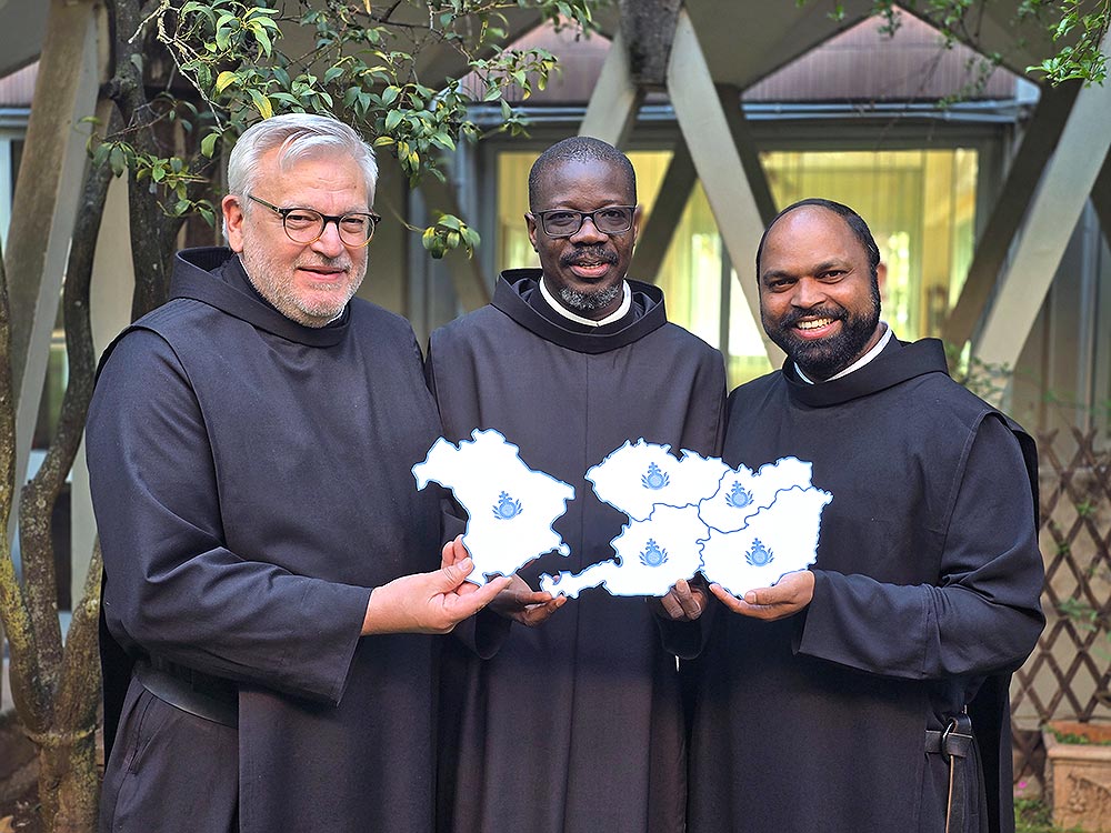 Das Bild zeigt Generalprior Pascal Ahodegnon (Mitte) mit dem bayerischen Provinzial Rudolf Knopp (li.) sowie dem österreichischen Provinzial Saji Mullankuzhy mit einer symbolischen Landkarte der künftigen Provinz.