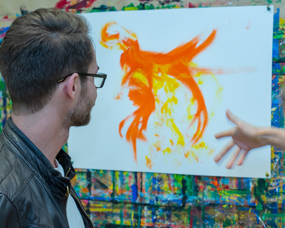 Zu sehen ist ein Patient bei der Kunsttherapie. 