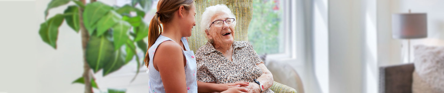 Das Bild zeigt eine Seniorin und eine Pflegerin.
