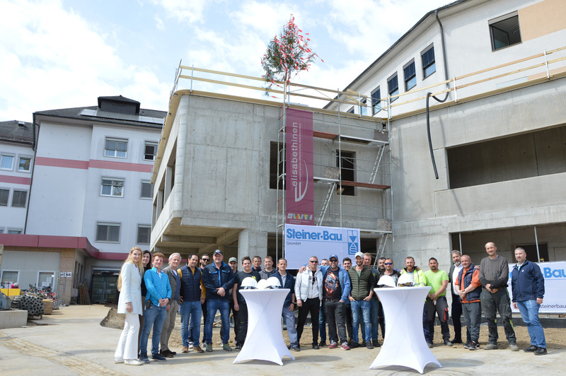 Gleichenfeier im EKH / EKH Meilenstein erreicht Gruppenfoto von Hausleitung und Bauleuten
