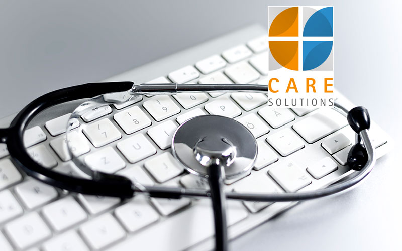 Das Bild zeigt eine Computertastatur mit einem Stethoskop und das Logo der Care Solutions GmbH in St. Veit/Glan.
