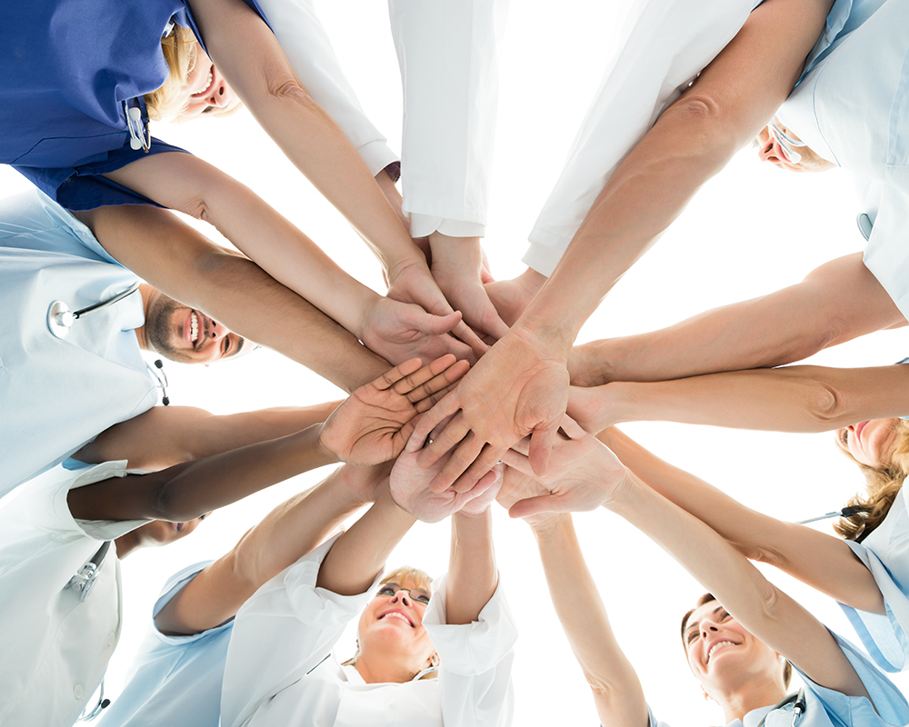Directly below shot of multiethnic medical team stacking hands over white background