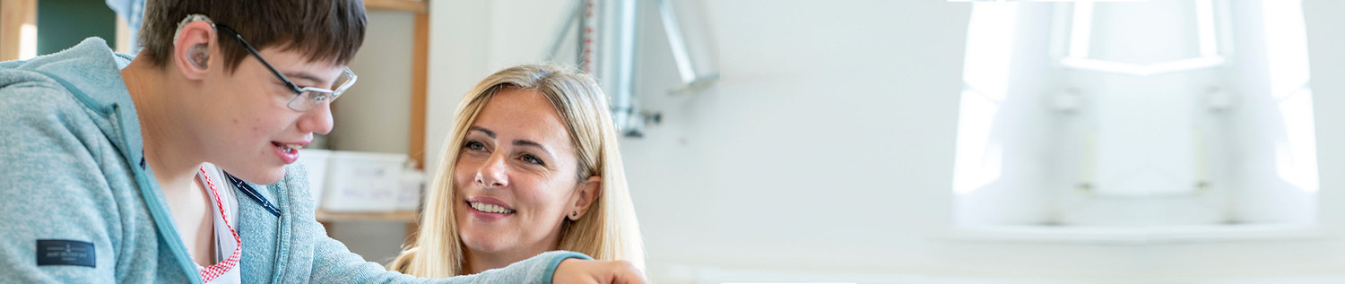 Eine Betreuerin schaut achtsam auf eine Bewohnerin