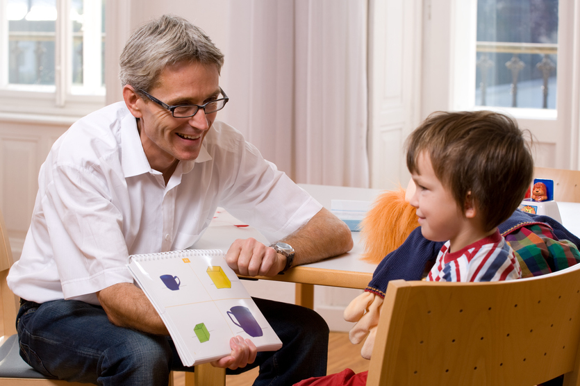 Das Bild zeigt ein Patientenkind mit seinem Betreuer.