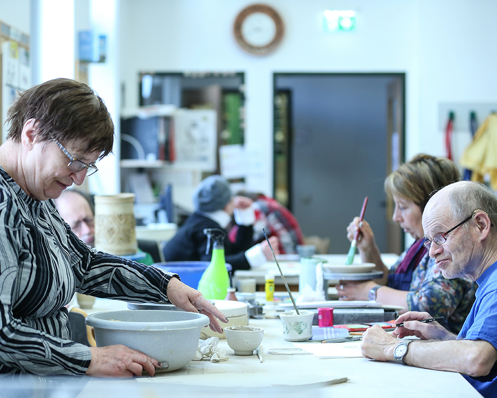 KundInnen arbeiten konzentriert in der Keramikwerkstatt