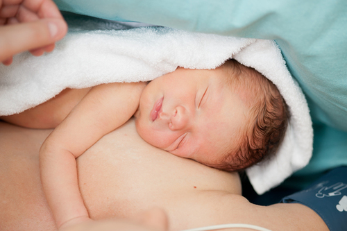 Neugeborenes Kind liegt auf der Mutter