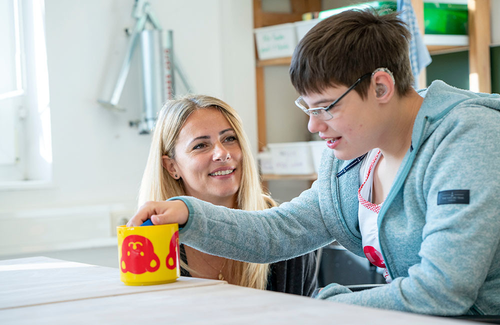 Eine Betreuung lächelt einer Bewohnerin zu
