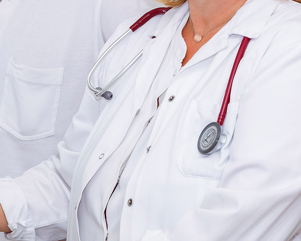 Hier ist eine Ärztin mit einem Stethoskop abgebildet. 