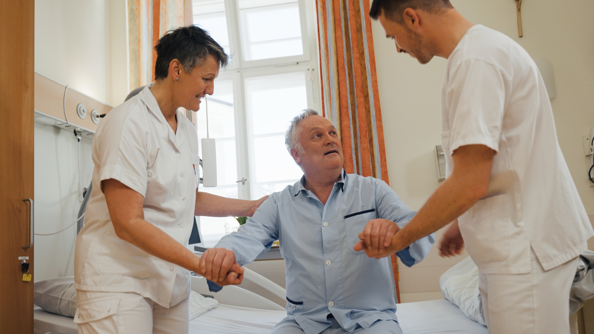 Die 2 Wanderbrüder im stationären Patientenzimmer bei der Mobilisierung des stationären Patienten