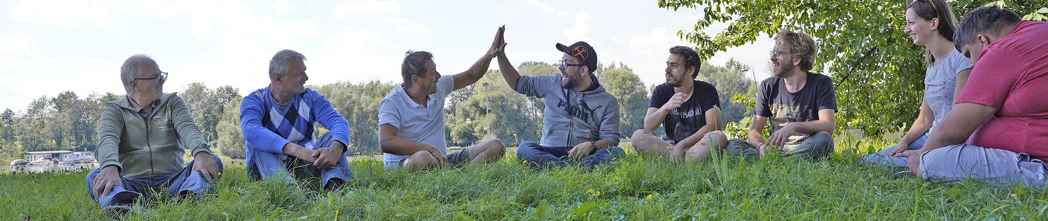 BetreuerInnen und BewohnerInnen sitzen gemeinsam in der Wiese