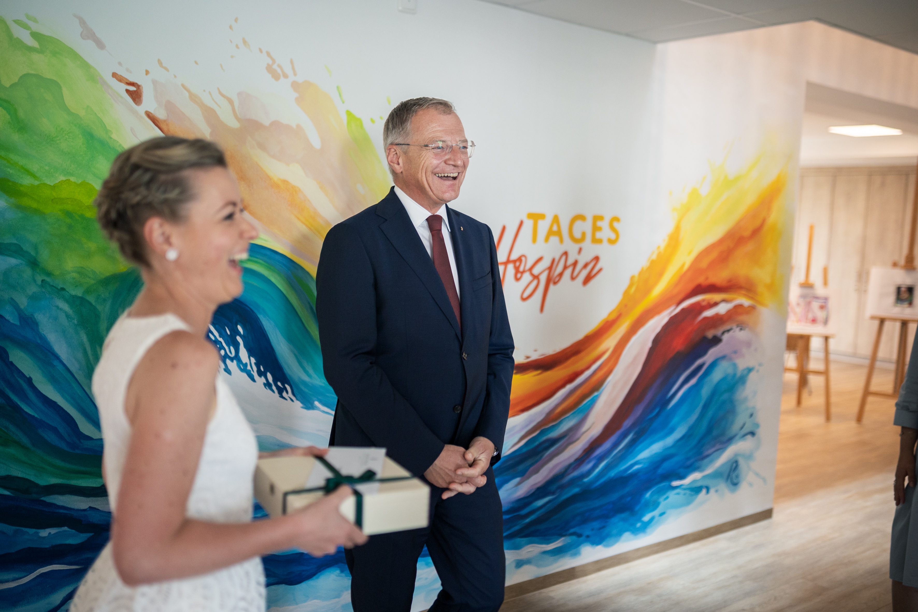 Das Bild zeigt eine Frau mit einem Präsent in der Hand, daneben steht Landeshauptmann Thomas Stelzer.