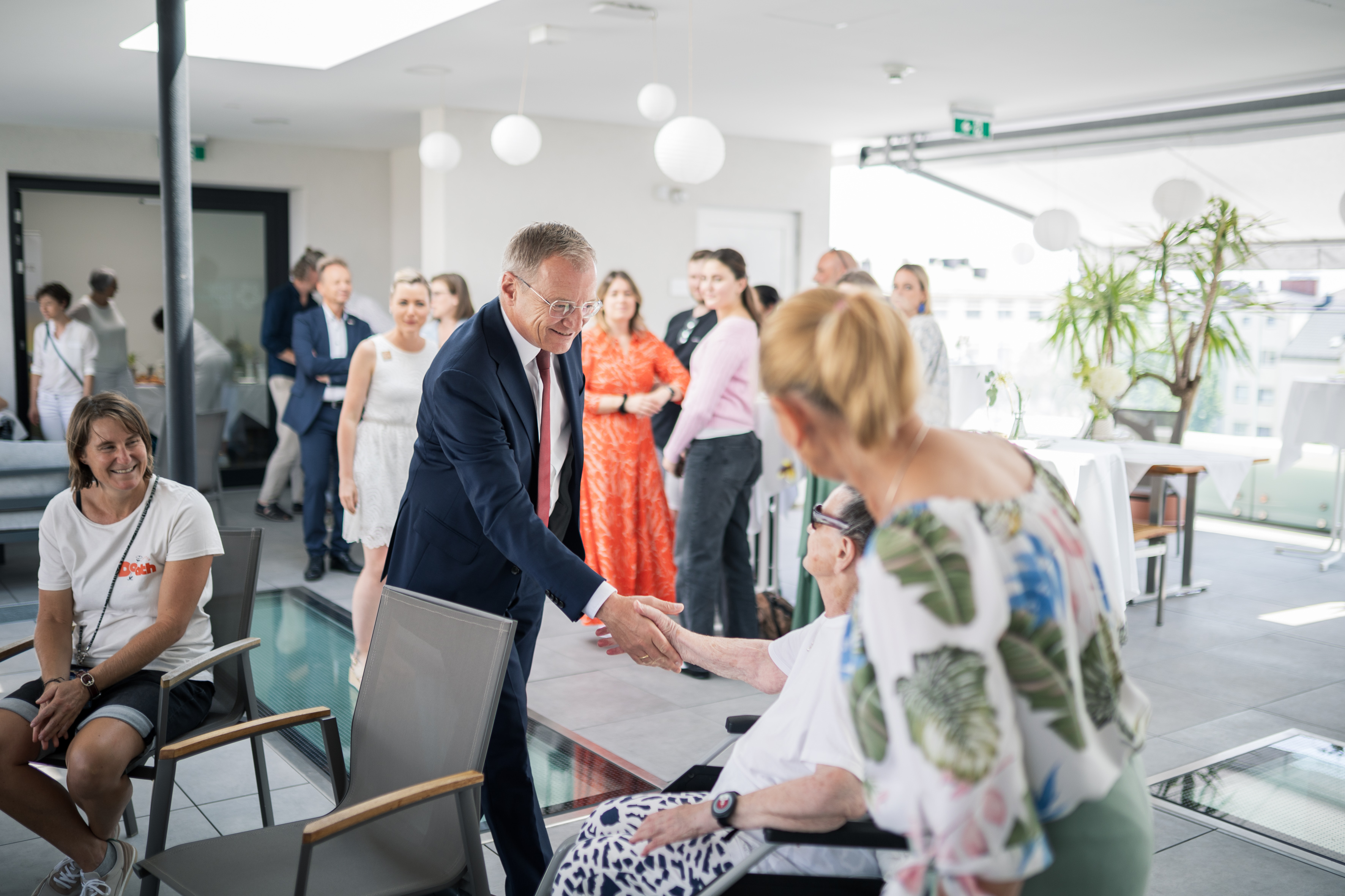 Landeshauptmann Thomas Stelzer begrüßt die Anwesenden im Sankt Barbara Hospiz, darunter eine Bewohnerin